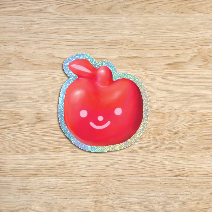 smiling apple sticker with glitter outline on a wood backdrop